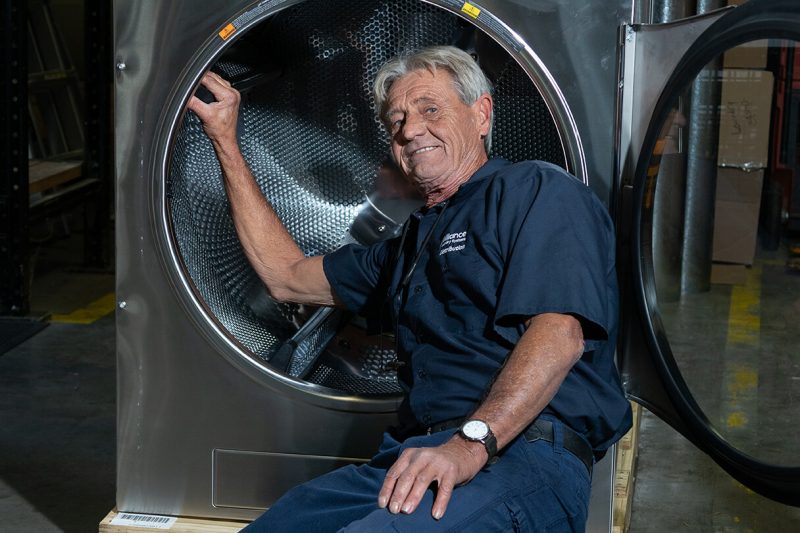 employee posing in front of washer